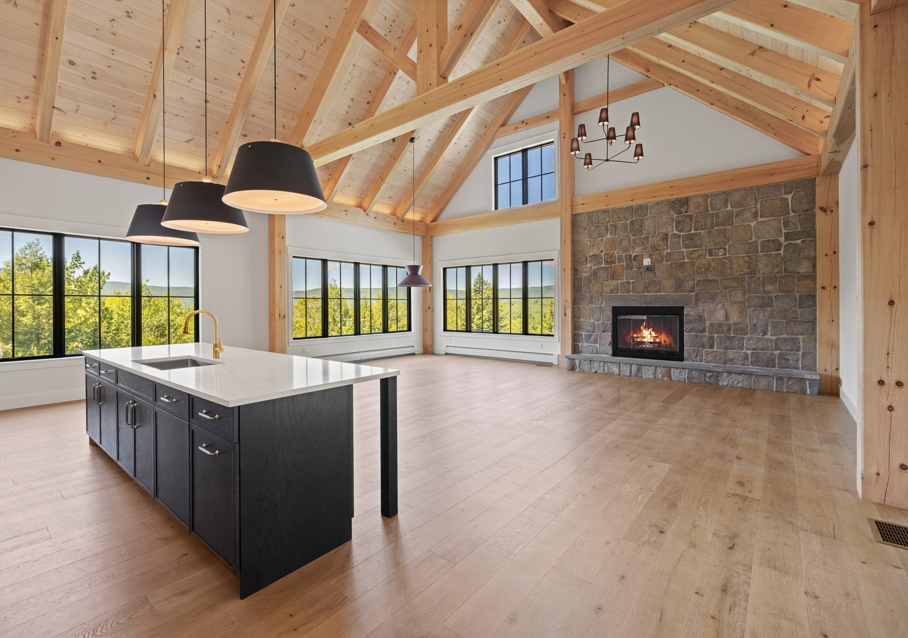 Great room with stone woodburning hearth and exposed beams