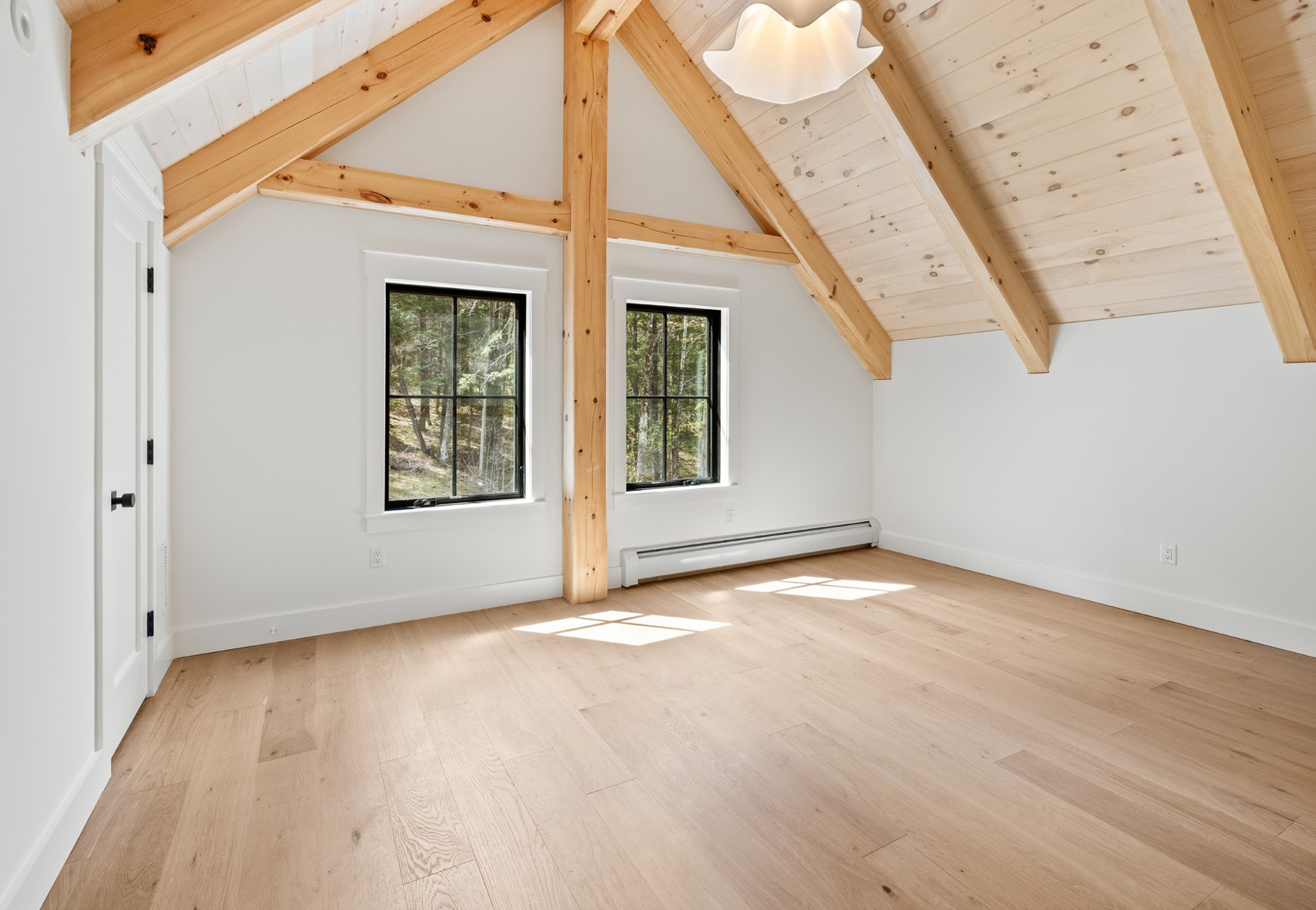 Top level bedroom with dramatic timber frame beams