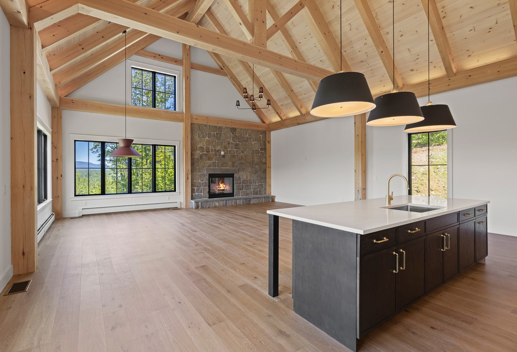 Timber frame great room with cathedral ceiling and kitchen island